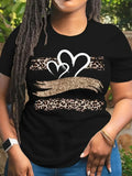 Close-up of black t-shirt with leopard heart and hands graphic worn on torso