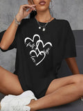 Black t-shirt with sequin heart graphic worn while seated