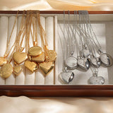Row of gold and silver photo lockets hanging on chains from a display rail