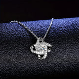 Close view of silver love knot pendant showing interwoven bands and crystal setting