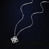 Silver love knot pendant with crystal stones on a fine chain against a dark background