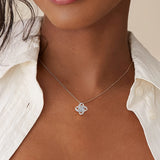 Woman wearing a silver love knot pendant necklace with crystal centre