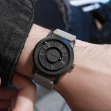 Hand holding black magnetic ball watch showing the pointerless dial face