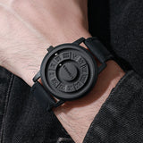 Black magnetic ball watch with black strap styled beside a dark denim jacket