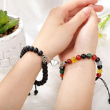 Two wrists wearing matching magnetic bead bracelets with black and multicolour stone beads