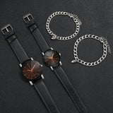 Silver heart charm bracelet displayed beside a black leather strap watch
