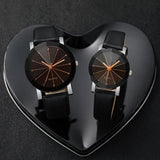 Two black leather strap watches displayed inside a heart shaped gift box