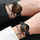 Two wrists clasped together each wearing a black leather strap watch