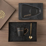 Navy blue tray and saucer set shown beside matching black mug with gold spoon