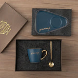 Teal tray and saucer set shown beside matching black mug with gold spoon