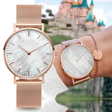 Rose gold mesh watches with white and pink pearl dials shown side by side outdoors
