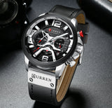 Blue dial rose gold watch on a leather strap shown at an angle on grey