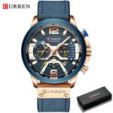 Rose gold blue dial chronograph watch on blue leather strap beside a black gift box