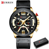 Gold case chronograph watch with black leather strap displayed beside a black gift box