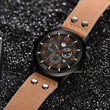 Angled military style watch showing black case, crown and tan leather strap