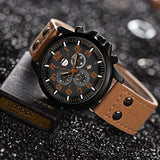 Black dial military watch with orange accents and sub-dials on tan leather strap