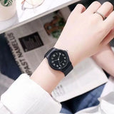 Two people clasping hands each wearing a matching black minimalist watch