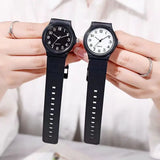 Two wrists side by side each wearing a matching black minimalist watch