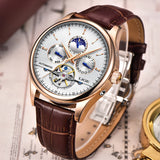 Automatic moon phase watch with white dial and brown strap worn on a wrist