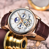 Rose gold automatic moon phase watch with brown strap styled beside gold coins
