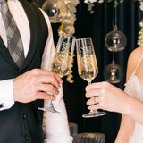 Bride and groom toasting with custom engraved champagne flutes at their wedding
