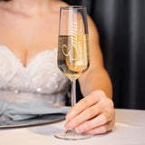 Bride in wedding dress holding a custom engraved champagne flute