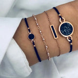 Navy cord and gold chain bracelet stack with disc charm worn on a wrist