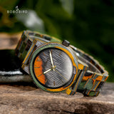 Wooden watch with camouflage patterned case resting on an outdoor rock surface