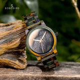 Wooden watch with camouflage patterned case resting on a tree branch