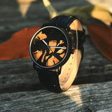 Dark wooden watch case shown close up on a dark wooden surface