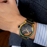 Wooden camouflage watch worn on wrist with a striped sleeve