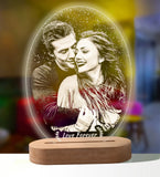Custom photo lamp of a couple glowing purple on a round wooden base