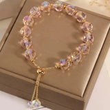 Pink crystal bead bracelet with hanging charm drop displayed on a white gift box