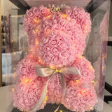 Pink foam rose teddy bear with gold ribbon bow in clear packaging