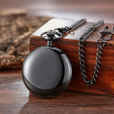 Silver pocket watch closed with chain coiled on a dark wood surface