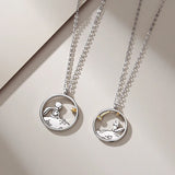 Silver prince and fox pendant necklaces with layered chains on beige background