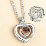 Rose gold heart pendant necklace with projection charm on beige fabric background