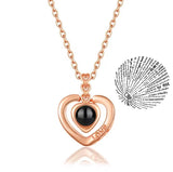 Rose gold heart pendant necklace with projection charm on cream background