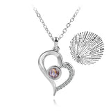 Silver heart outline pendant necklace paired with a round projection charm