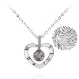 Silver heart pendant necklace with projection charm on cream background