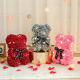 Three rose flower teddy bears in red, grey and pink with black ribbon bows and rose petals