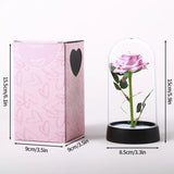 Pink foil rose in a glass dome beside a pink printed gift box with dimensions