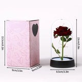Red foil rose in a glass dome beside a pink gift box with dimensions marked