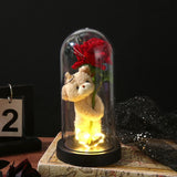 White foil rose in a glass dome beside a pink gift box with size measurements