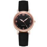 Front view of rose gold watch with black dial and slim black strap