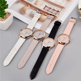 Four rose gold women's watches with grey, white, black and pink straps grouped together