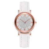 Angled rose gold watch with white strap and pale dial on white background