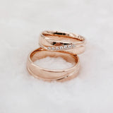 Rose gold couple wedding rings with crystal line design shown interlocked together