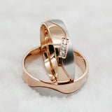 Rose gold couple wedding rings with crystal line design stacked together on white fur