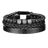 Black three piece bracelet stack with crystal charm and Roman numeral bar on white background